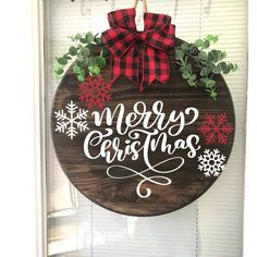 a wooden sign that says merry christmas hanging on a window sill with snowflakes