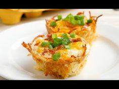 two small casserole cups on a white plate with green onions and scallions