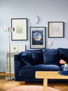 a living room with blue couches and pictures on the wall above it, along with a coffee table