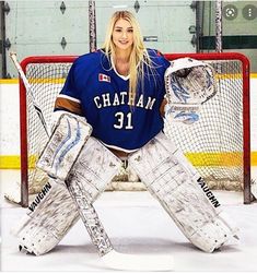 a female hockey goalie sitting on the ice with her goaltenders gear in front of her