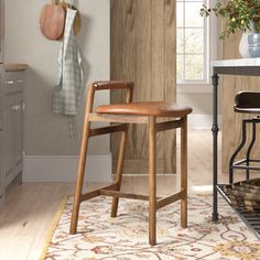 a kitchen area with stools, counter and potted plant