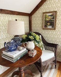 there is a table with books and vases on it in the corner of this room