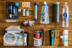 the contents of a water bottle laid out on a wooden table with other items around it