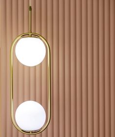 two round lights hanging from the ceiling in front of a wall with vertical blind blinds