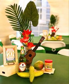 an arrangement of food and drinks on a table in a room with green tables cloths