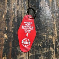 a red keychain hanging from the side of a wooden wall