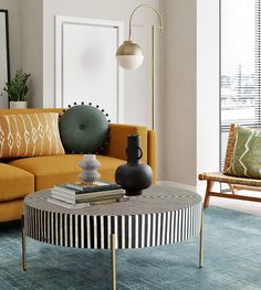 a living room filled with furniture and a yellow couch in front of a large window