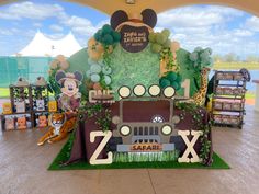 an outdoor stage set up for a mickey mouse birthday party with balloons and decorations on it