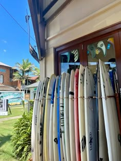 several surfboards are lined up in front of a window on the side of a building