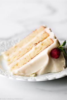 a slice of cake with white frosting and raspberries