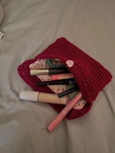 the contents of a crocheted bag are laying on a bed