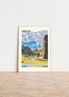 an image of the oregon state with mountains in the background and clouds above it, on a wooden floor