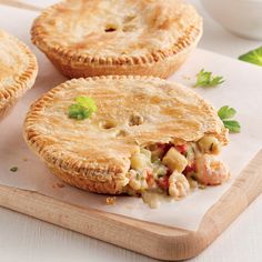 three pies with meat and vegetables on a cutting board