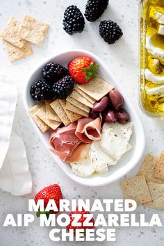 a bowl filled with cheese, crackers and fruit