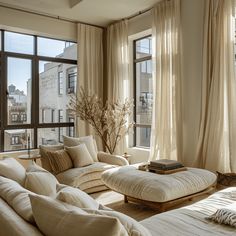 a living room filled with lots of furniture next to large window covered in drapes