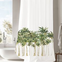 a shower curtain with palm trees on it in front of a bathtub and window