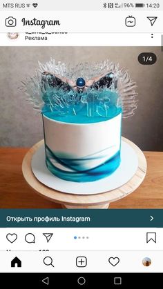 a cake with blue icing and frosting on the top is sitting on a table