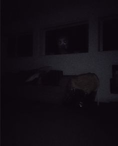 a dark room with two windows and a cat in the window