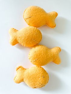 three yellow fish shaped pastries on a white surface