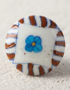 a blue flower sitting on top of a white and brown object in the middle of sand