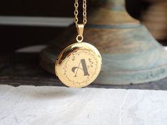 "Beautiful and classic, this round Victorian-inspired locket necklace features places for two photos inside. Personalize yours a vintage calligraphy initial with a floral motif surround. This treasured keepsake pendant and chain are both 14k gold plated stainless steel so are both hypo-allergenic and tarnish proof.   This locket isn't just a piece of jewelry; it's a vessel for your most precious memories. Whether it's a token of love, a symbol of a cherished bond, or a memento of a significant moment, this customizable gold locket holds the promise of preserving what matters most to you. Wear it close to your heart, carrying a photo, a tiny keepsake, or a secret message--whatever holds significance for you. Its versatile style seamlessly complements any outfit, making it a timeless additio Vintage Calligraphy, Customize Jewelry, Locket Jewelry, Engraved Locket, Gold Locket Necklace, Photo Locket Necklace, Jewelry Lockets, Gold Locket, Jewelry Picture