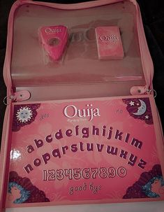 an open pink suitcase with letters and numbers in the bottom part, inside is a black background