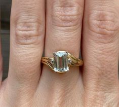 a woman's hand with a ring on it and an emerald stone in the middle