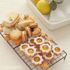 there are many cookies and pastries on the cooling rack with lemons in the background