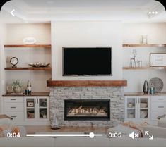 a large flat screen tv mounted on the wall above a fireplace