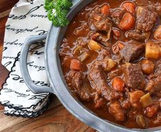 a pot filled with stew on top of a wooden table