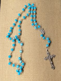 "Silver Tone Blue Speckled Bead Rosary.  Rosary is 23\" long.  Preowned.  Good Condition."