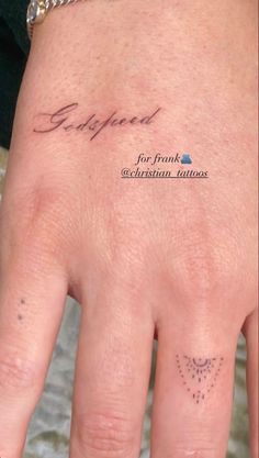 a person's hand with a small tattoo on it