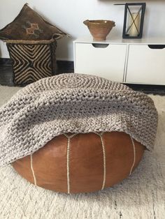 a large round ottoman sitting on top of a white rug