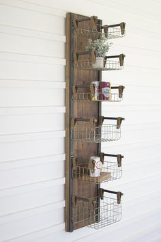 a wall mounted shelf with several baskets on it and some cups in the bottom rack