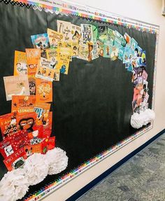 a bulletin board with many books on it in an empty classroom area, decorated with white pom - poms