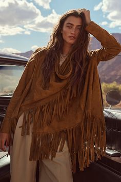 Bold and beautiful, the Trisha wrap jacket boasts 7" of fringe along its hem for movement and western-inspired style. Crafted from soft, supple goatskin suede leather, it can be worn two ways, both equally stunning: open, with the sides cascading down; or wrapped, with one side secured at the shoulder with a corozo button closure. Either way, you'll be the picture of rustic elegance. Featuring lined sleeves for comfortable wear. Wrap is 31 3/4" long plus 7" of fringe along hem. Bohemian Long Sleeve Leather Jacket For Fall, Bohemian Long-sleeve Leather Jacket For Fall, Winter Leather Tassel Outerwear, Winter Leather Outerwear With Tassels, Bohemian Winter Outerwear With Beaded Fringe, Leather Tassel Outerwear For Fall, Long Sleeve Leather Jacket For Fall Festivals, Fall Leather Tassel Outerwear, Fall Festival Long Sleeve Leather Jacket