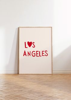 an art print with the words los angeles printed on it in front of a white wall