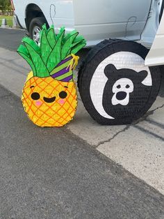 two pineapples and a black bear are sitting next to each other on the street