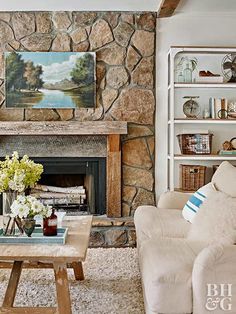 a living room filled with furniture and a fire place in front of a stone fireplace