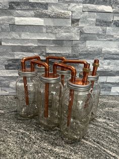 four mason jars with copper pipes in them