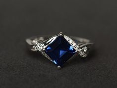 Welcome to my shop, you can find many beautiful gemstone jewelry here, and you also can ask for customized service. Main Stone: lab created sapphire, square cut, measures 7X7mm, weight 2.27 carats;Accent Stones: CZMetal: 925 sterling silver plated with rhodium. I also can provide metal options such as 14k solid yellow/white/rose goldSetting: prong settingMy shop home: https://www.etsy.com/shop/XCjewelryStudio?ref=hdr_shop_menuIt's a perfect gift for the person who was born in September (Birthsto Rectangular Sapphire Ring With Accent Stones, Sapphire Ring With Square Diamond Cut, Blue Square Cut Sapphire Promise Ring, Square Cut Blue Sapphire Promise Ring, Square Cut Sapphire Ring With Diamond Detail, Rectangular Lab-created Sapphire Ring For Anniversary, Anniversary Rectangular Lab-created Sapphire Ring, Blue Sapphire Ring With Square Cut, Square Cut Sapphire Ring As Gift