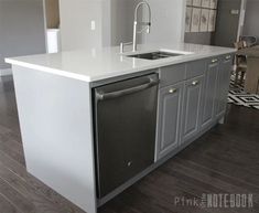 a kitchen with an island, sink and dishwasher in the middle of it