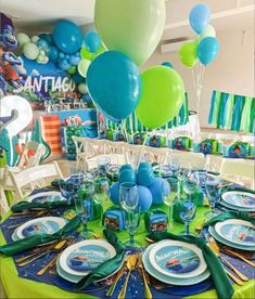 a table set with plates and balloons for an under the sea birthday party at disney's art of animation resort