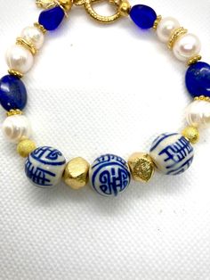 This bracelet is made with three Chinese chinoiserie beads, freshwater pearls, navy lapis and gold plated accents. It is closed with a gold plated toggle closure. Please measure your wrist and add 1/2 to 3/4 inch and order that size from the drop-down. Thank you for visiting. I use strong stringing materials, sterling silver crimps and wire guards at the closure, for durability.  FREE SHIPPING Blue Pearl Bracelet Gift, Handmade Elegant Blue Pearl Bracelet, Handmade Gold Beaded Lapis Lazuli Bracelets, Elegant Handmade Blue Pearl Bracelet, Chinese Chinoiserie, Bracelet Bead, Jewelry Style, Pearl Shell, Beautiful Bracelet