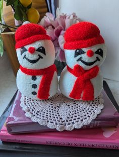 two snowmen sitting on top of a pink book