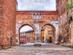 an old brick building with two archways in the center and one on the other side