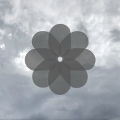 an image of a large flower in the sky with clouds behind it and below it