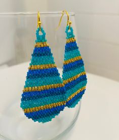 Beautiful and bright multicolor turquoise, blue and gold glass Miyuki seed bead earrings are woven in a stripe pattern with and finished with a gold ear wire and accents. Classic and flattering. I'm always happy to customize if you have something specific in mind. All items are handmade by yours truly and come from a smoke free home. Thanks for looking! Turquoise Teardrop Beaded Earrings As Gift, Turquoise Teardrop Beaded Earrings For Gifts, Turquoise Teardrop Earrings With Tiny Beads, Teardrop Beach Jewelry With Colorful Beads, Turquoise Teardrop Jewelry For Crafting, Blue Beaded Long Drop Jewelry, Blue Earrings With Spacer Beads For Gift, Colorful Beads Teardrop Jewelry For Crafting, Colorful Beads Long Drop Jewelry Gift