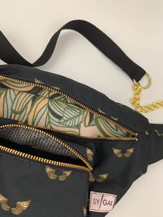 an image of a black bag with gold zippers