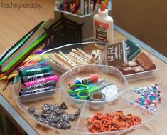 a clear tray filled with craft supplies on top of a wooden table